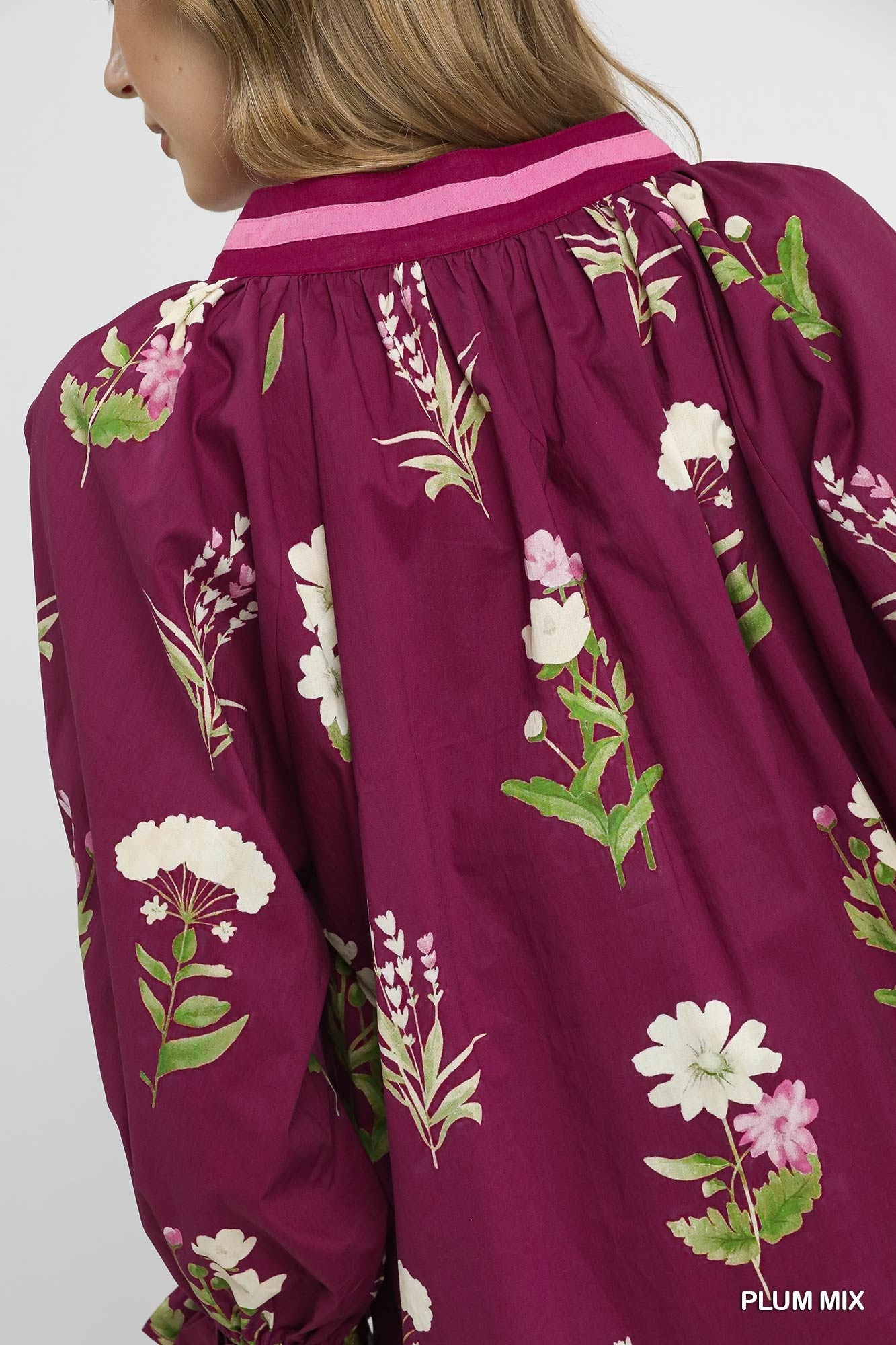 Close-up of a purple garment with floral patterns on a plain background